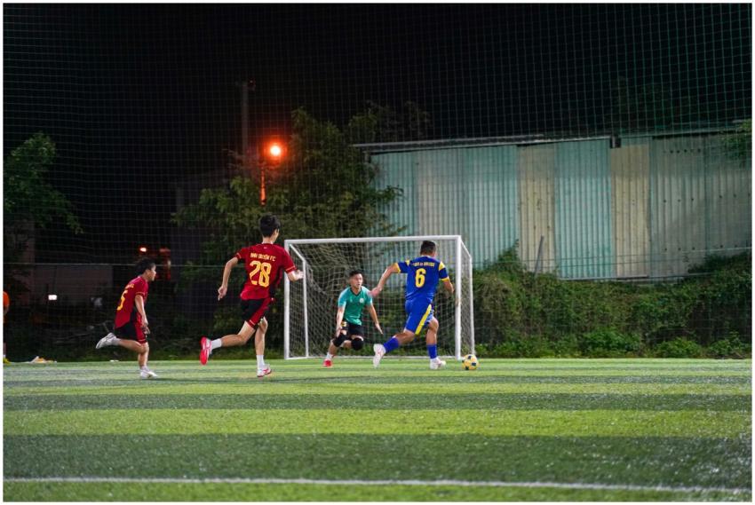 Youth soccer players in action on a lit field at n