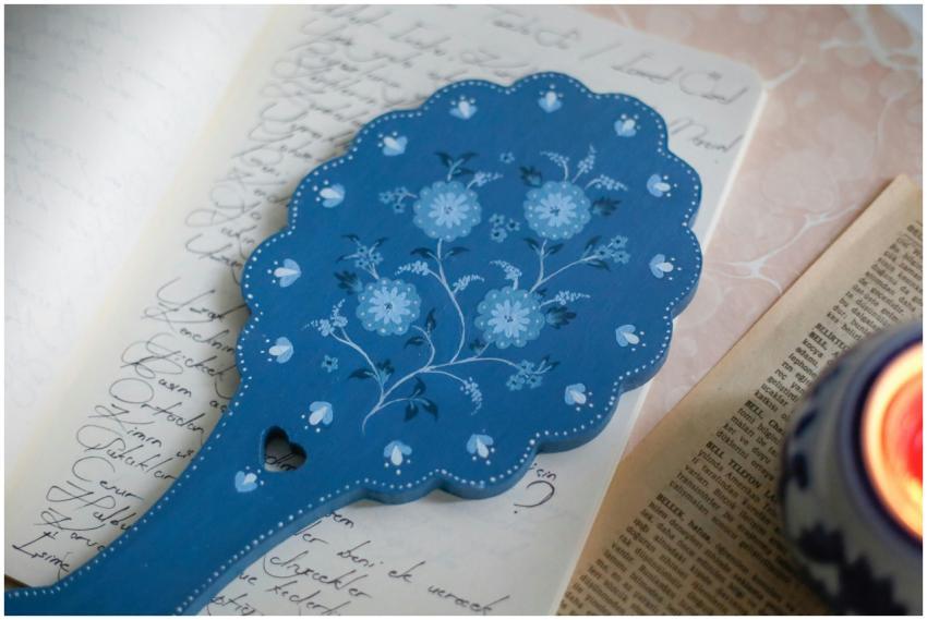 Elegant blue wooden fan with floral design rests o