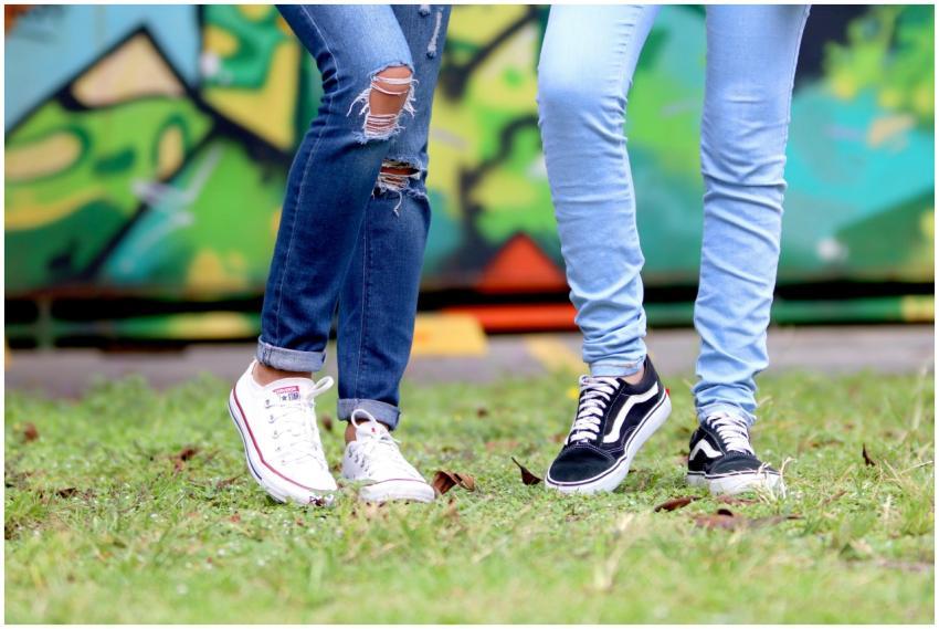 Two young adults wearing trendy jeans and sneakers