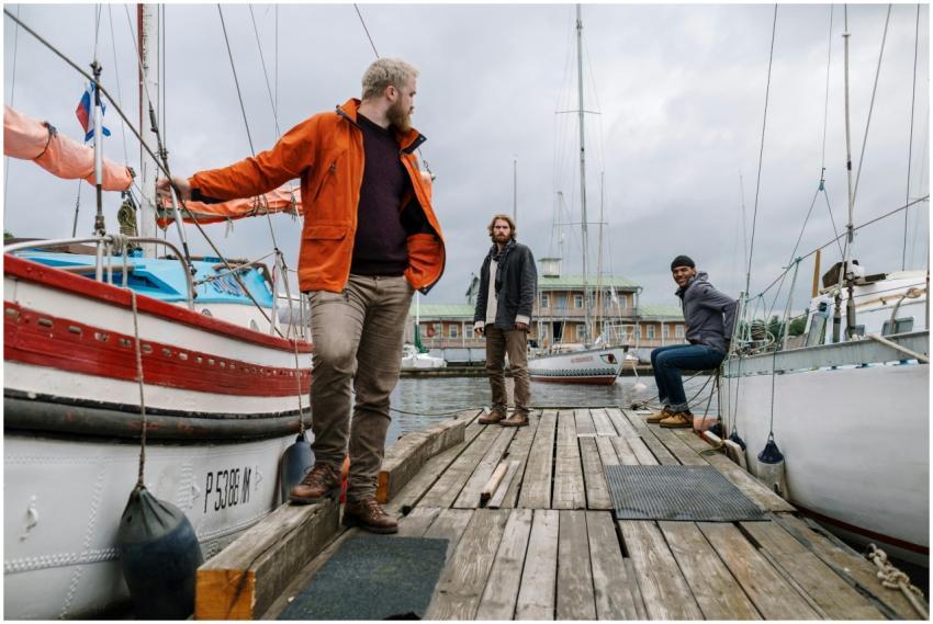 Casual gathering of men at a marina with boats on
