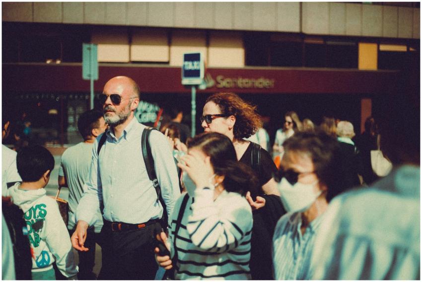 An urban street filled with a diverse crowd walkin
