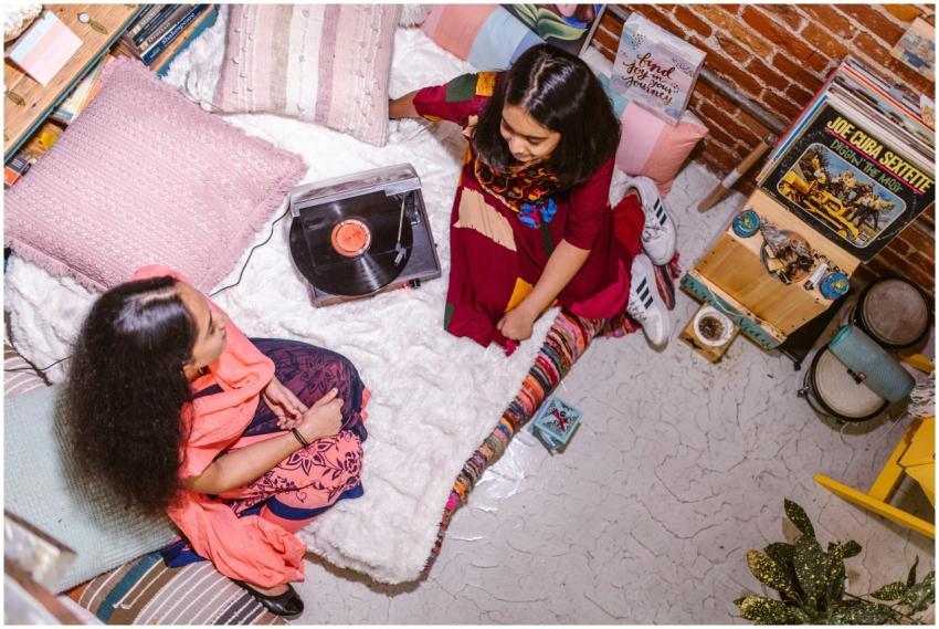 Two girls enjoying music on a vinyl record player