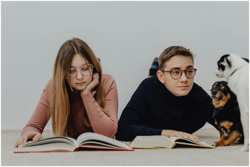 Two young adults reading books indoors with attent