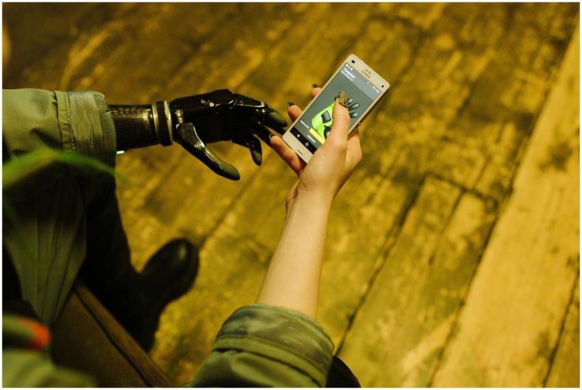 Person with prosthetic hand operating a smartphone
