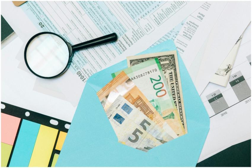 Close-up of tax documents and mixed currency in a