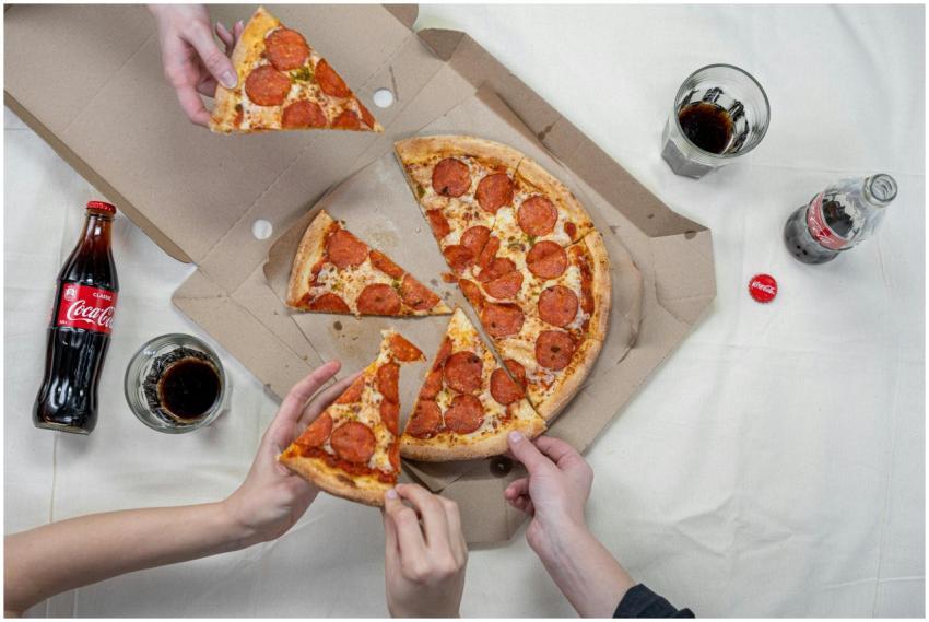 Top view of friends sharing a pepperoni pizza with