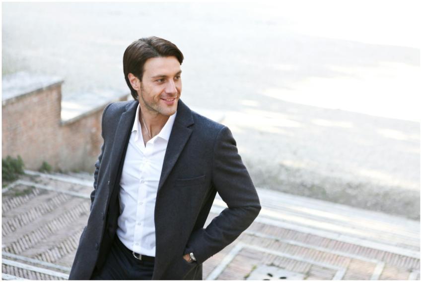 Confident man in a suit smiling while walking outd