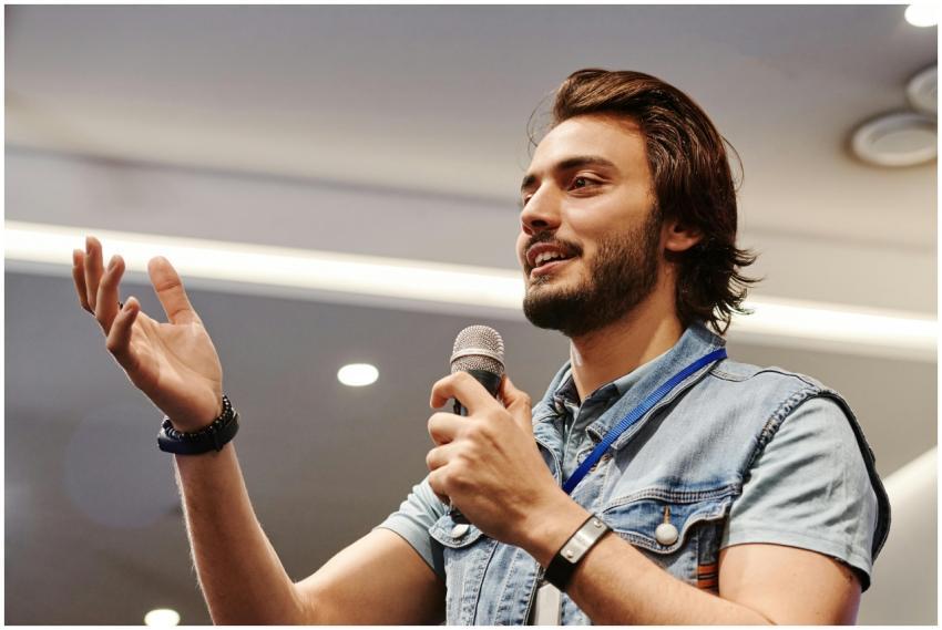 Young man with microphone speaking confidently at