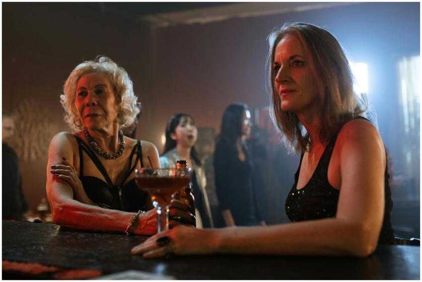 Two women sitting at a bar, enjoying a cocktail du