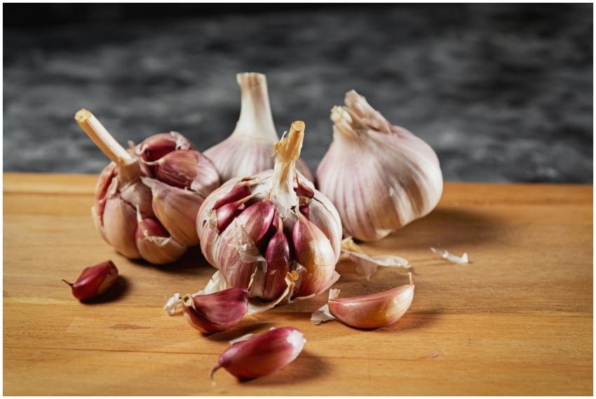 Close-up of fresh garlic bulbs and cloves on a woo