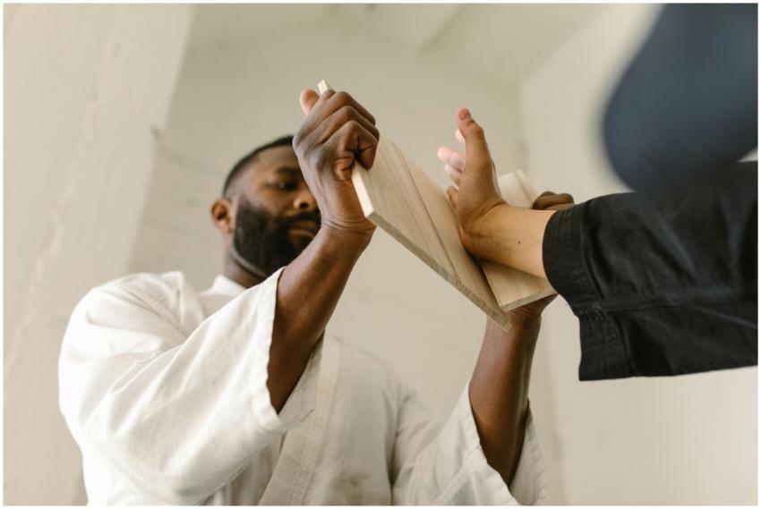 Martial artist breaking a board during training in