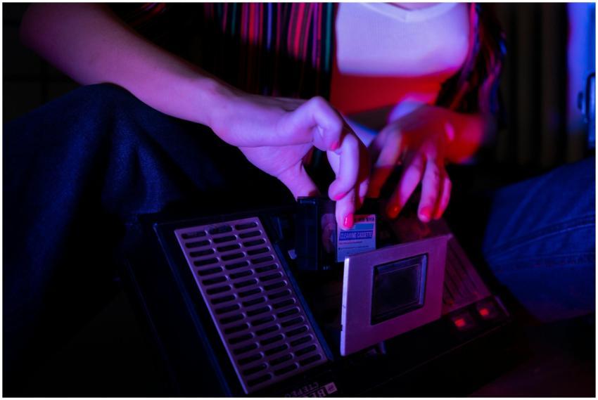 A woman adjusts a retro cassette player, highlight