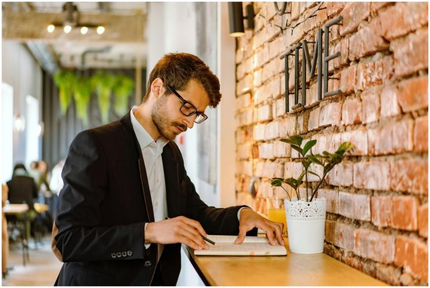 A professional man in a café setting taking notes
