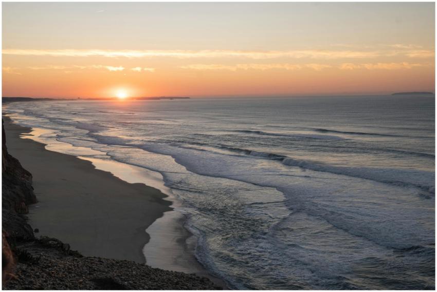 Stunning sunset over Nazaré beach with waves huggi