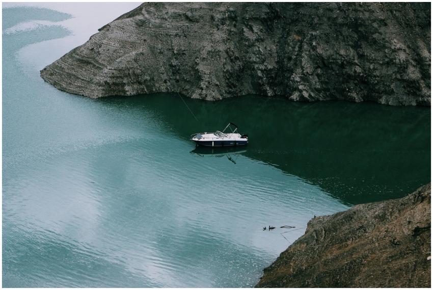 A serene boat navigates a quiet cove surrounded by