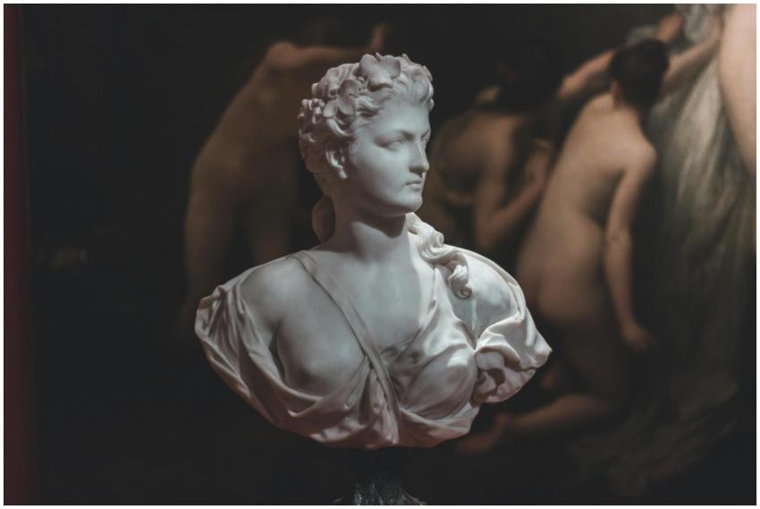 A marble bust sculpture displayed in a dimly lit,