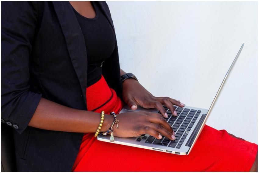 A black female freelancer typing on a laptop while