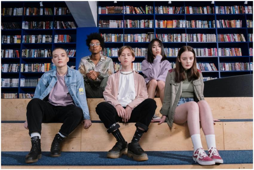 A group of diverse teenagers sitting in a library,
