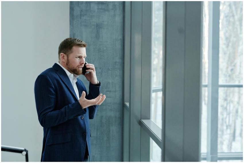 Businessman using smartphone while standing indoor