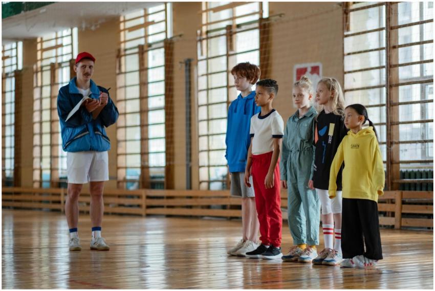 A coach instructing a diverse group of children du
