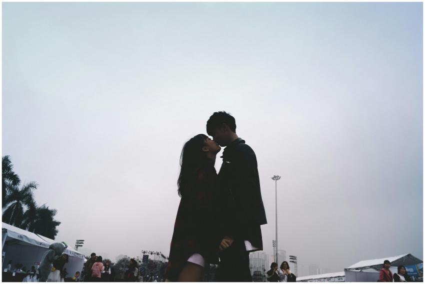 A romantic silhouette of a couple kissing outdoors