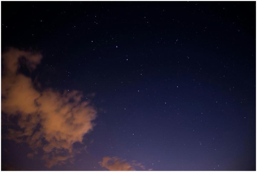 Beautiful starry night sky with soft clouds visibl