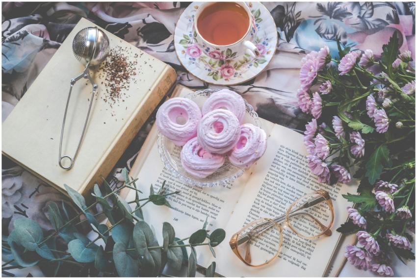 Delicate flatlay with pink pastries, tea, flowers,
