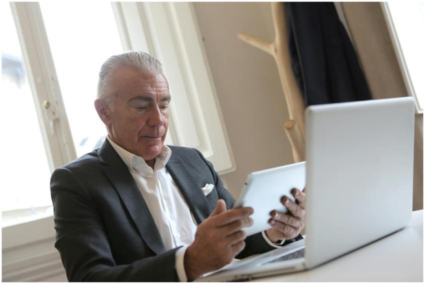 Senior businessman in office attire working on a t