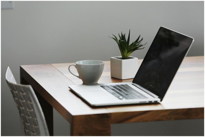 Cozy and modern workspace featuring a laptop, coff