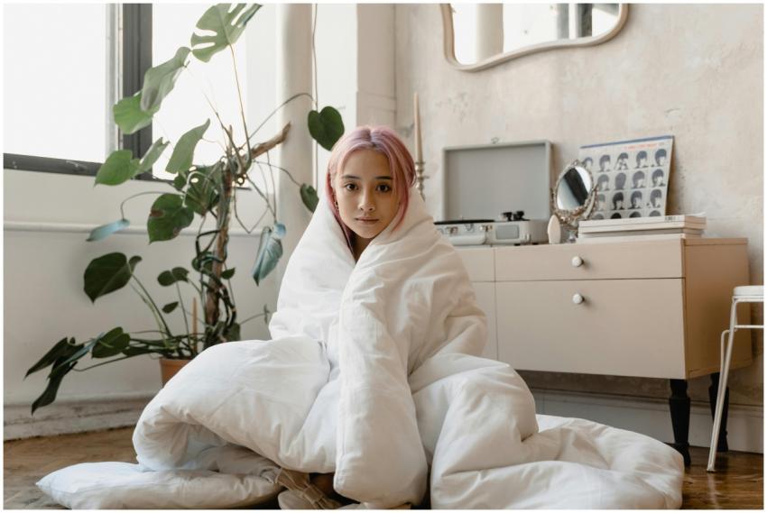Young woman with pink hair wrapped in a blanket, e