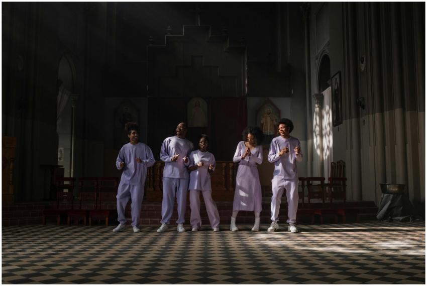 A choir group singing in a church, illuminated by