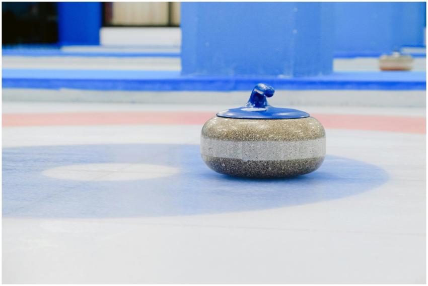 A close-up view of a curling stone on a vibrant in