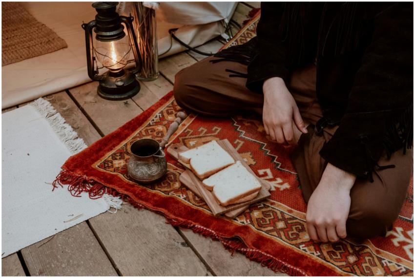 A cozy indoor setup with sandwich, lantern, and tr