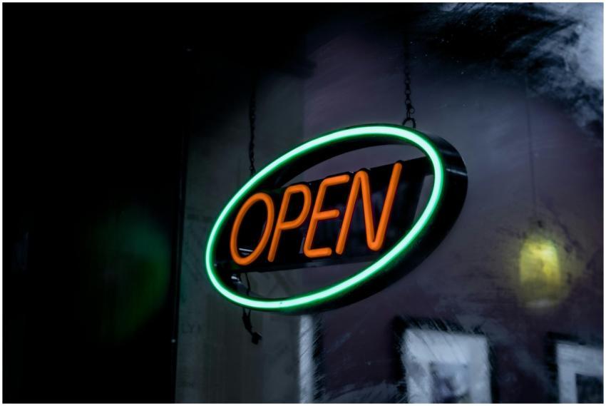 Vibrant neon open sign glowing in a dimly lit sett