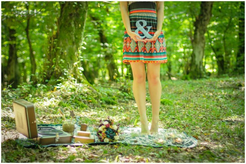 A woman enjoying a vibrant picnic in a sunlit fore