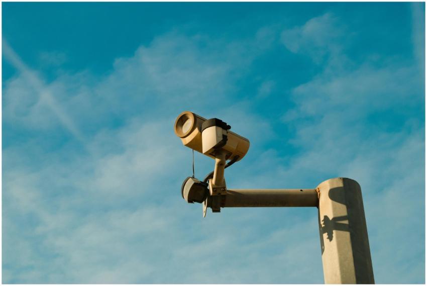 A surveillance camera mounted outdoors against a b