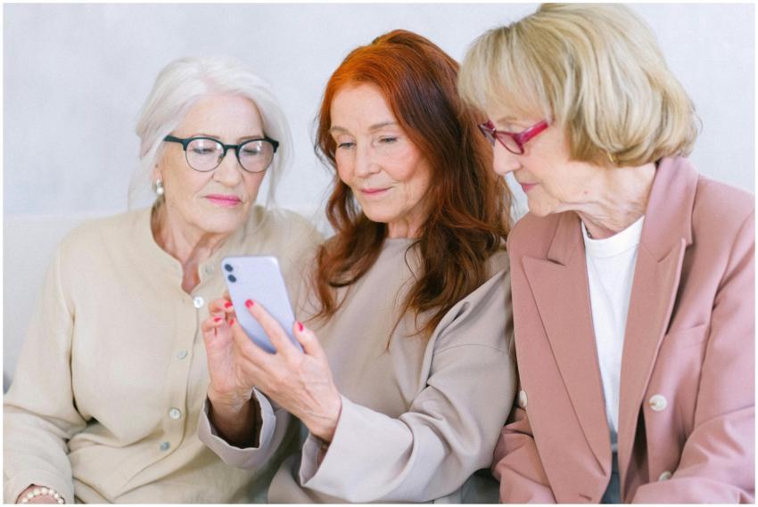 Three senior women browsing a smartphone together,