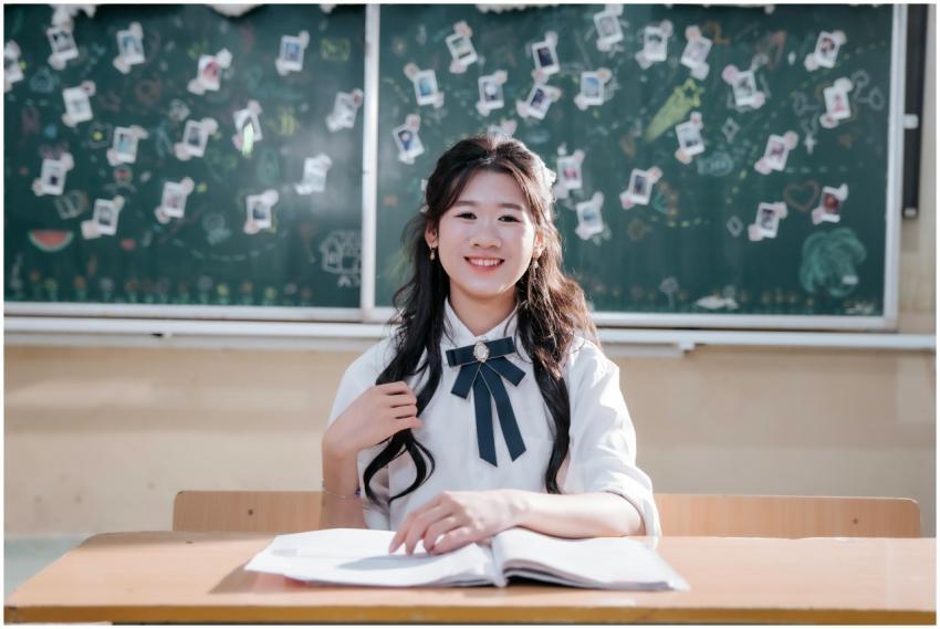 A cheerful student sitting at a desk in a classroo