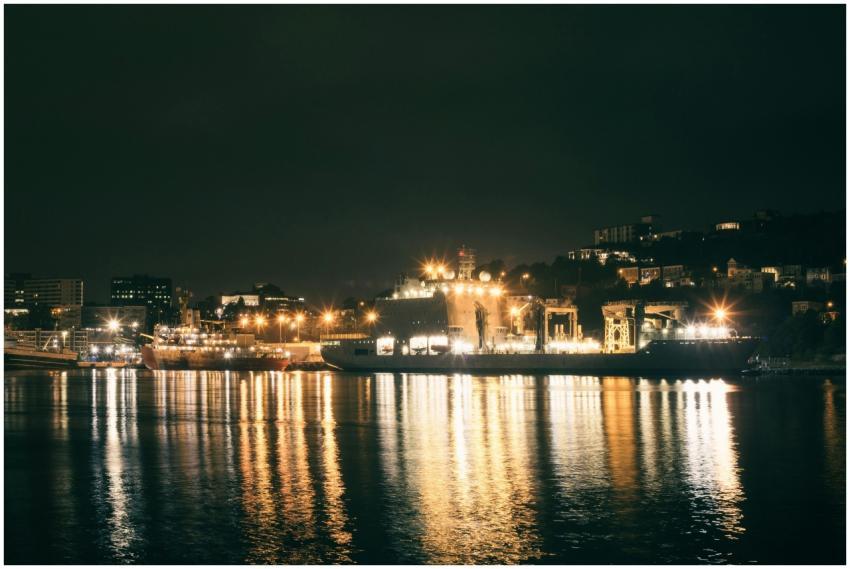 Scenic night view of a city harbor with illuminate