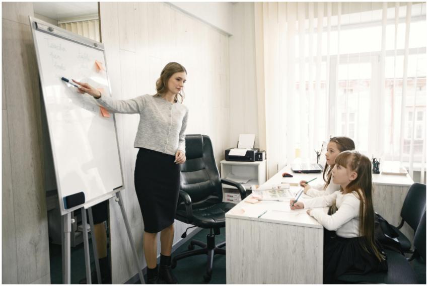A female teacher guiding two girls during a lesson