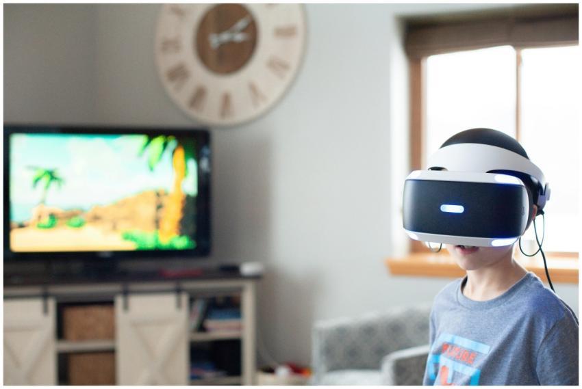 A boy wearing a virtual reality headset, enjoying