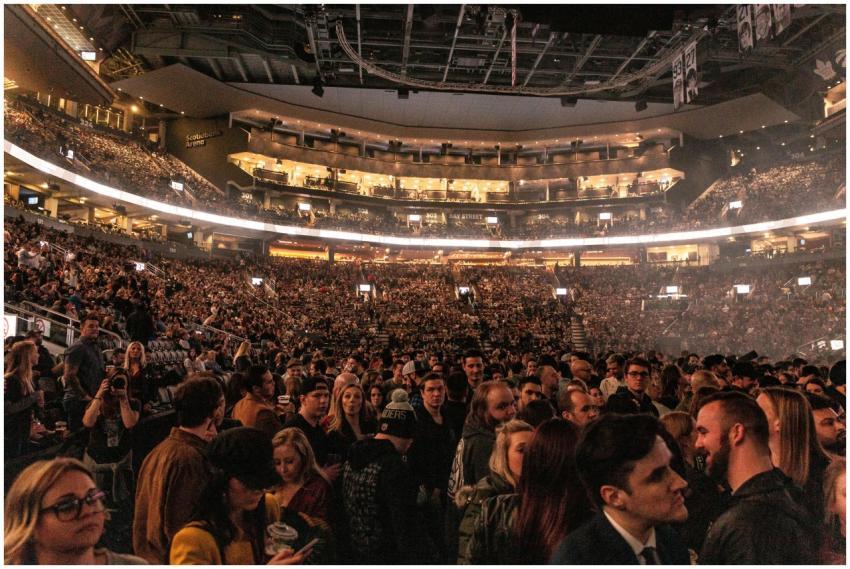 A large crowd gathers in an indoor arena for a liv