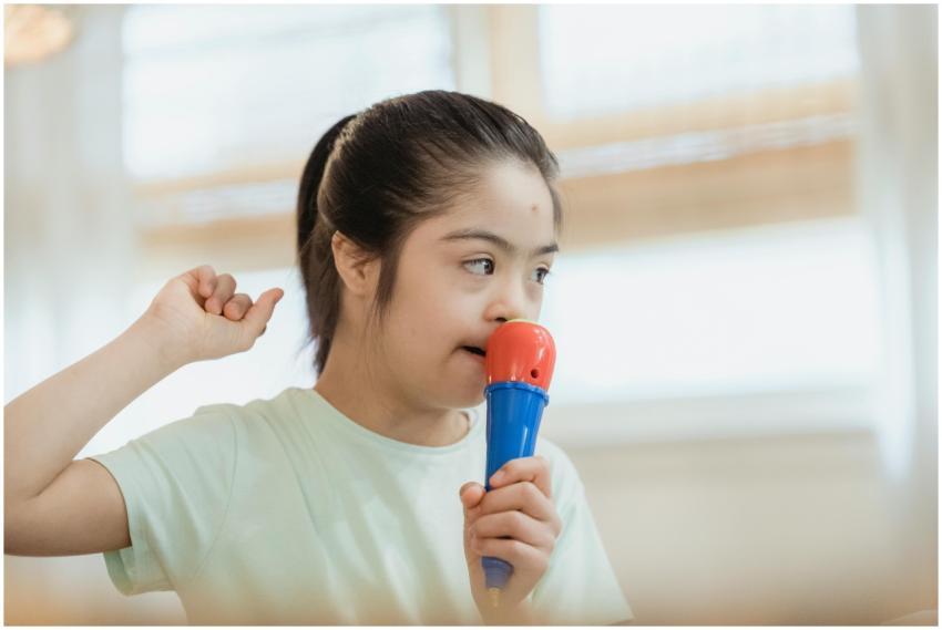 Young girl singing into a toy microphone, expressi