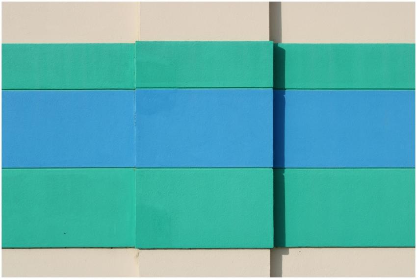 Abstract wall art in teal and blue hues on a beige