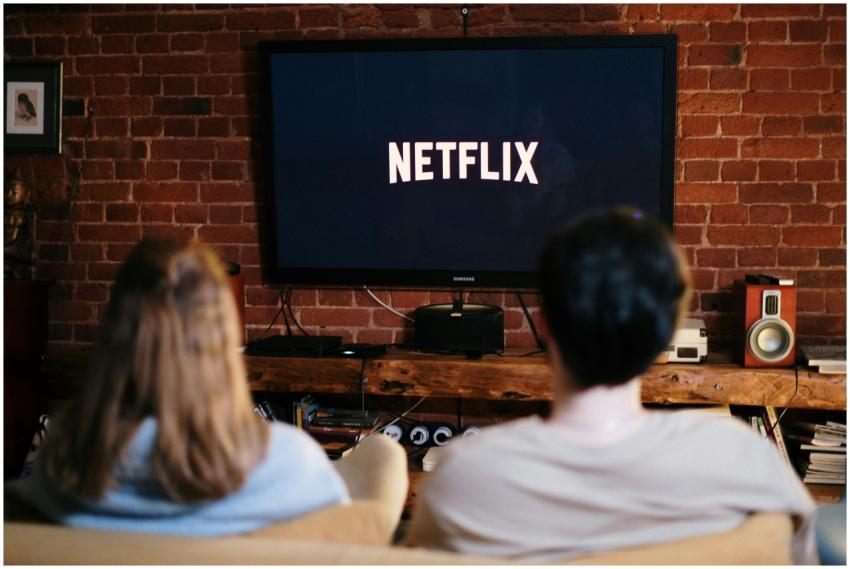 A couple relaxing and watching Netflix in a cozy l