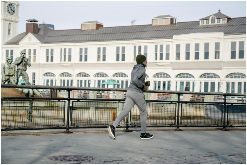 A man jogs outdoors near a historical building, pr