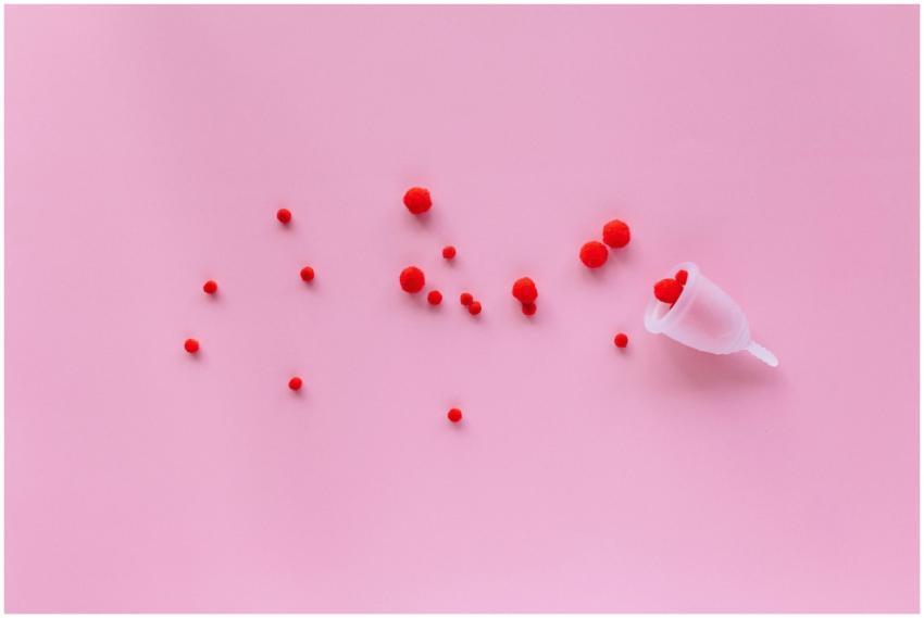 Menstrual cup with red elements on pink background