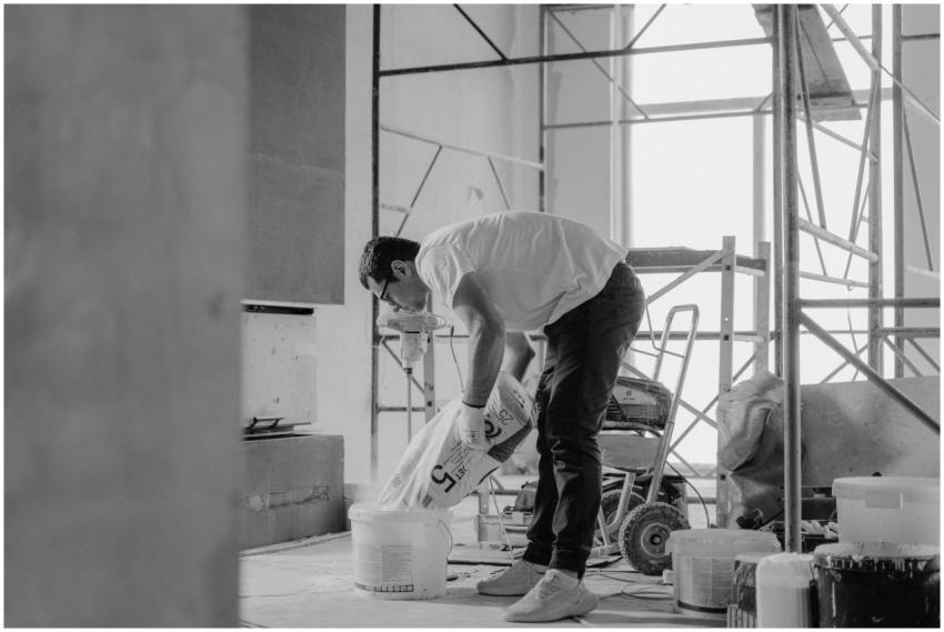 A construction worker pours materials inside a bui
