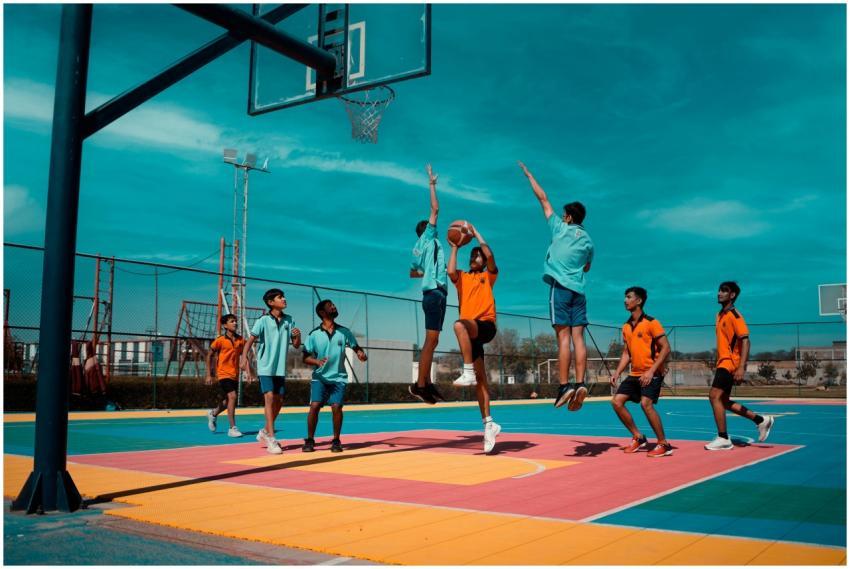 Young players actively playing basketball on a vib