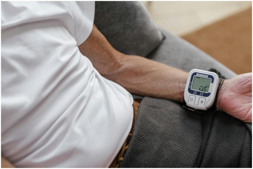 Adult man using a wrist blood pressure monitor to